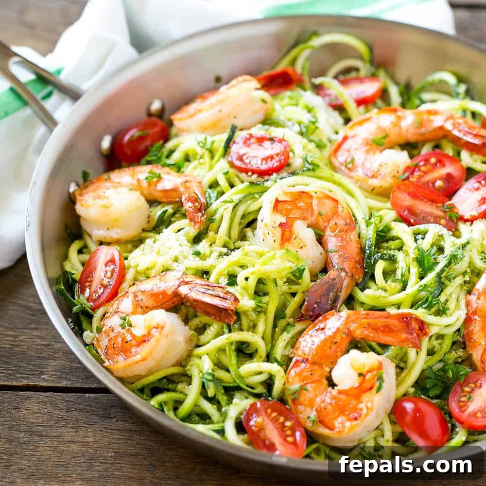 Vibrant Pesto Shrimp Zoodles 4 A bowl of pesto zoodles with shrimp and tomatoes, ready to be served.