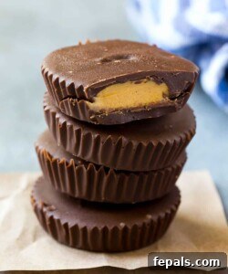 Finished protein peanut butter cups, stacked invitingly on parchment paper, ready to be enjoyed as a healthy and delicious treat.