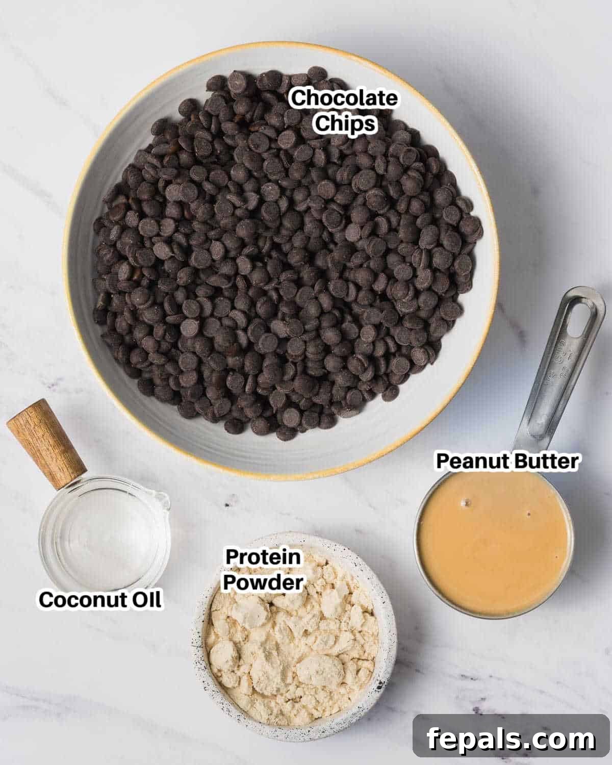 A vibrant selection of ingredients for making protein peanut butter cups, including jars of peanut butter, a bag of chocolate chips, protein powder, and coconut oil.