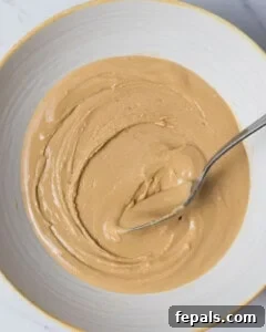 A bowl with peanut butter and protein powder being mixed together until a smooth, creamy texture is achieved, forming the core of the filling.