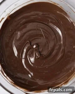 A bowl of rich, dark chocolate perfectly melted and ready to be used as a luscious coating.