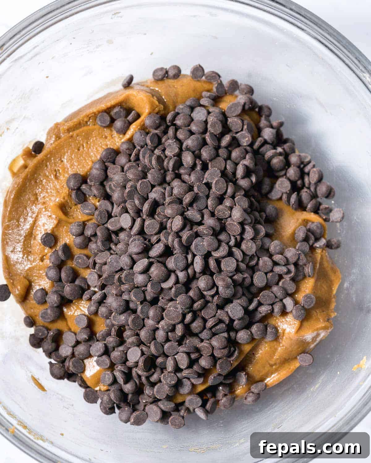 Power-Packed Protein Chocolate Cookies 8 Chocolate chips gently folded into the protein cookie dough in a mixing bowl.