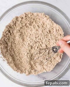 Dry ingredients like almond flour, protein powder, and baking powder are mixed in a bowl.