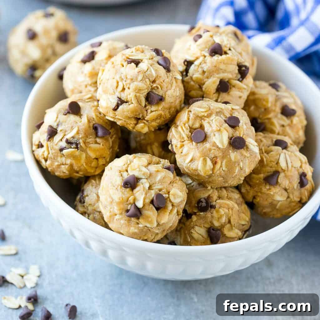 A side shot of a white bowl overflowing with delicious peanut butter and oats energy balls, showcasing their perfectly round shape.