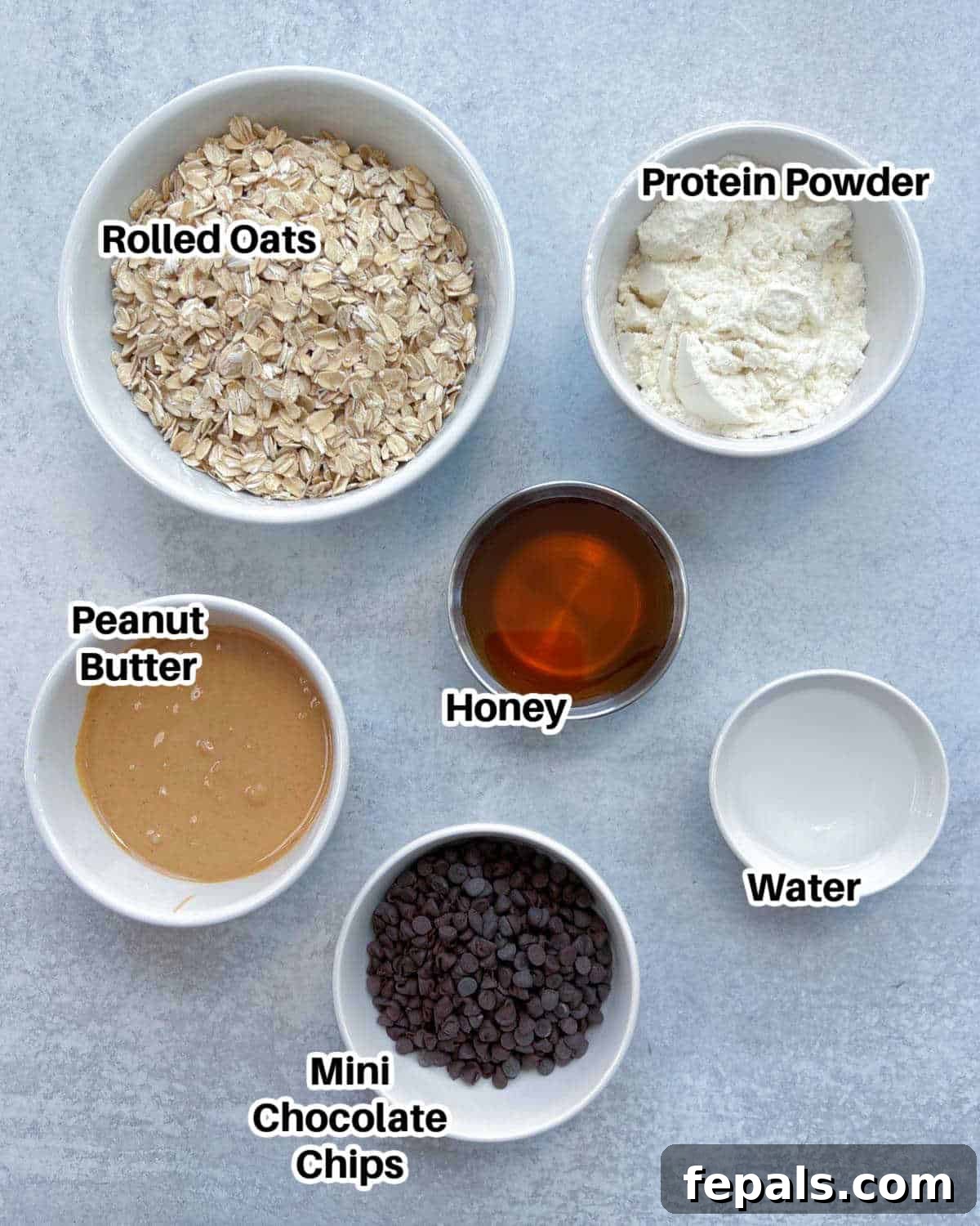 A flat lay image displaying all the individual ingredients required to make protein energy bites, neatly arranged on a countertop.