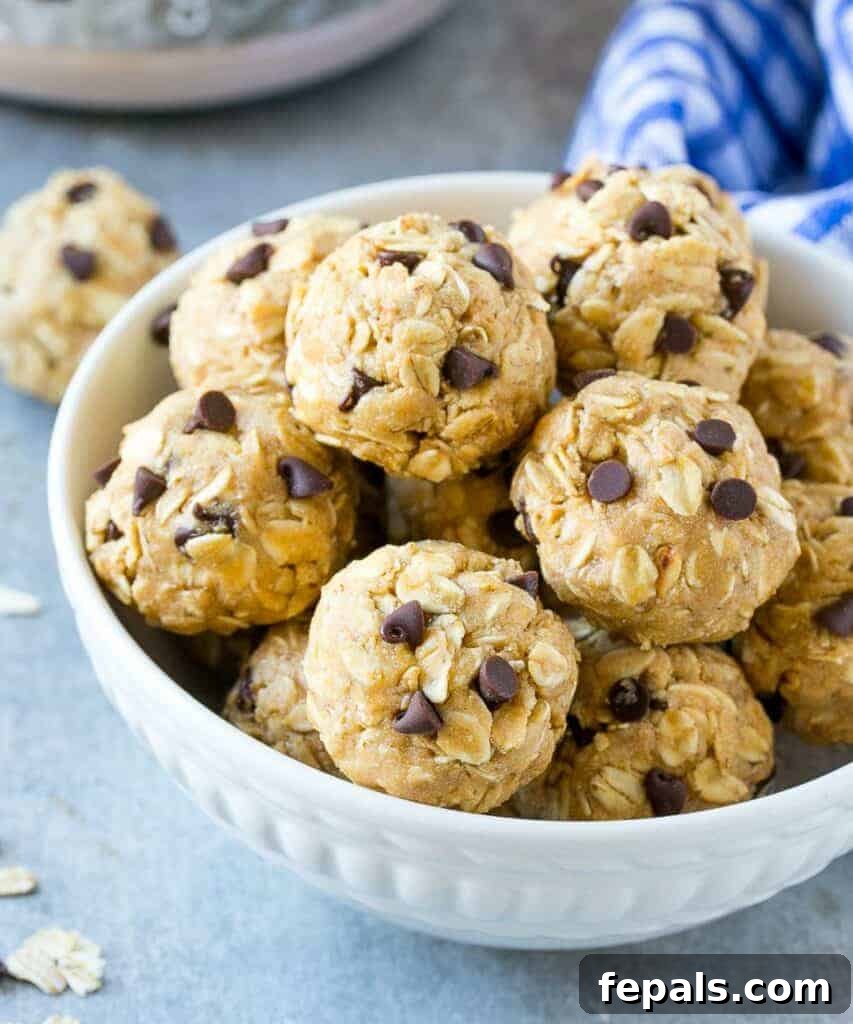 A stack of perfectly round protein energy bites in a small, elegant white bowl, ready for enjoyment.