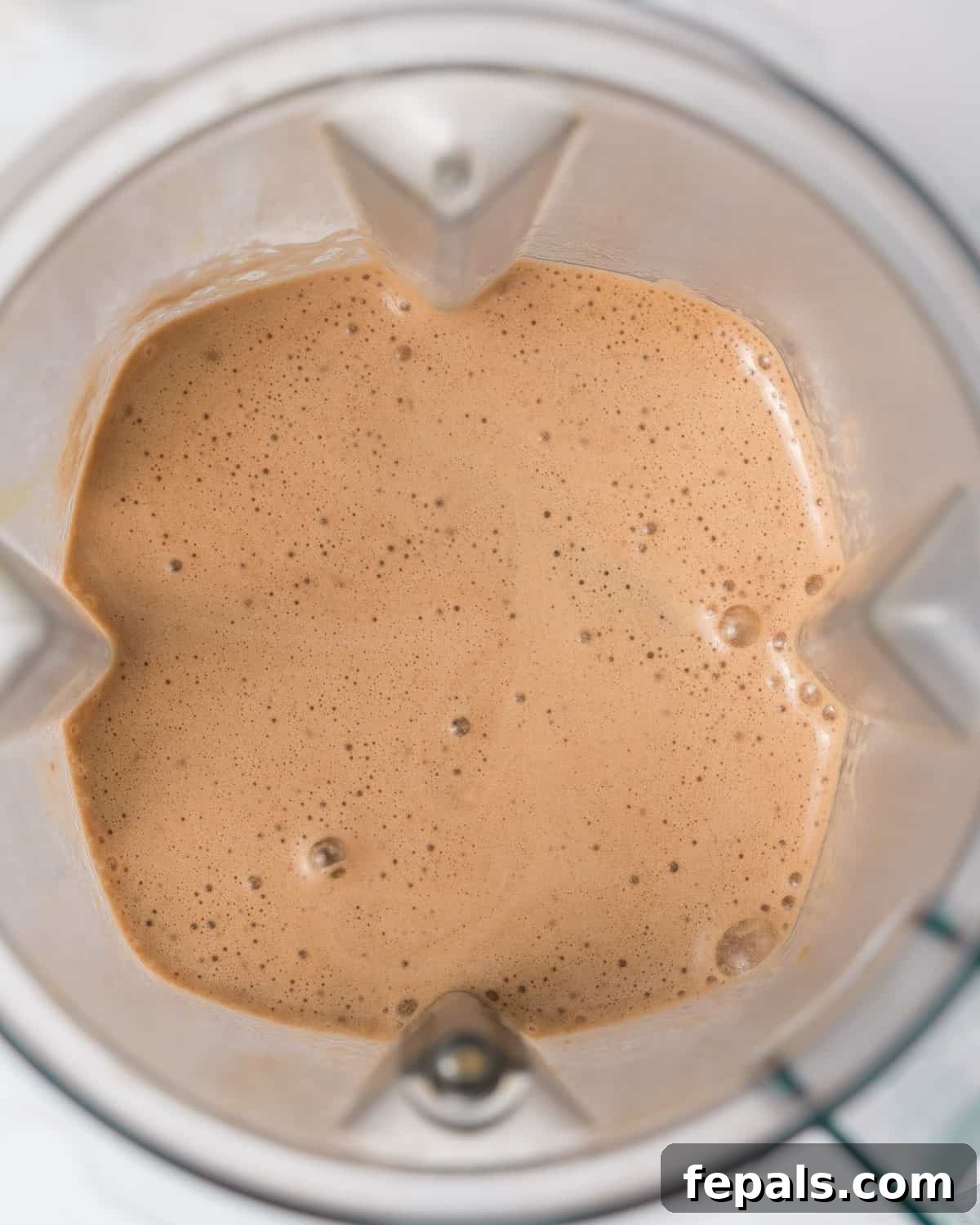 The mocha protein shake ingredients are thoroughly blended to a smooth and creamy consistency within the blender, indicating readiness.