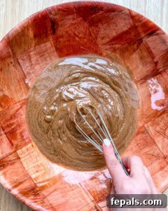 whisk mixing the nut butter, honey, and coconut oil.