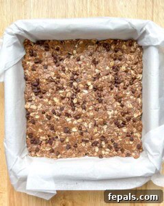 protein bar dough pressed on a pan lined with parchment paper.