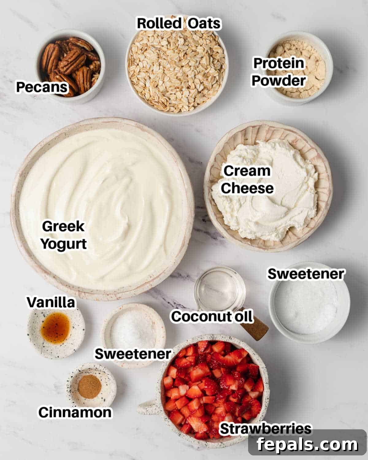 A flat lay photograph showcasing all the ingredients required to make protein cheesecake cups, neatly arranged on a countertop.