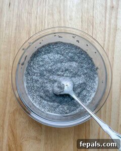Creamy Coconut Chia Seed Pudding 8 spoon mixing the chia pudding in a bowl.