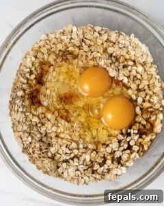 Eggs added in with vanilla over the oat mixture.