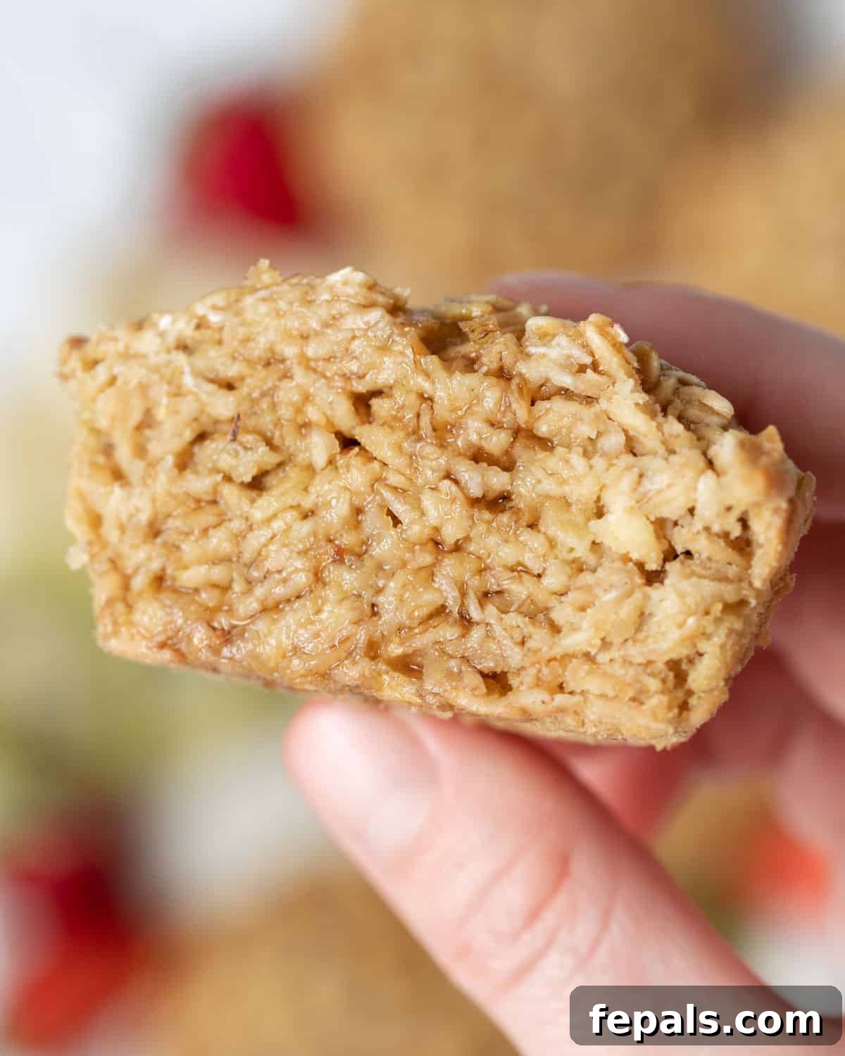 A hand gently holds half of a freshly baked protein muffin, showcasing its moist texture.