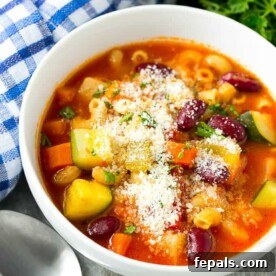 Vegetable Soup that is tomato based in a round white bowl