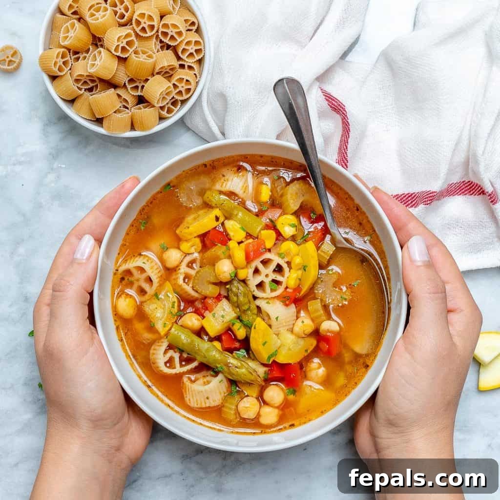 hand holding bowl of vegetable soup
