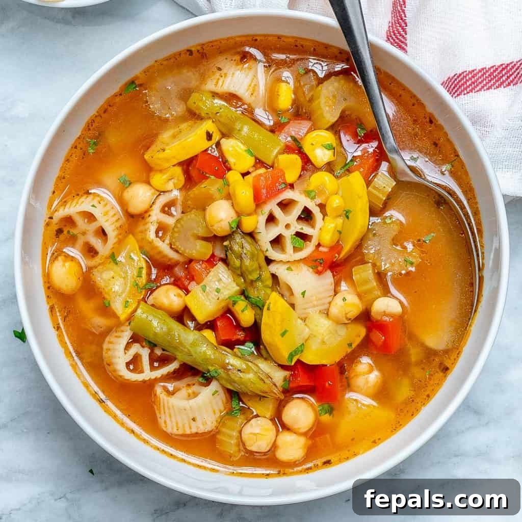 close up of veggie soup with spoon in it 
