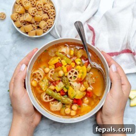 hand holding bowl of vegetable soup