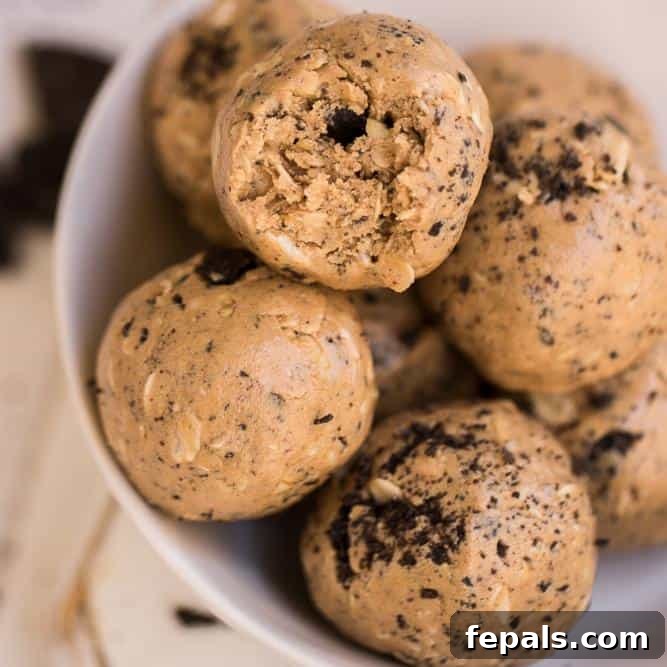 Close-up view of energy balls with one having a bite taken, revealing its rich texture