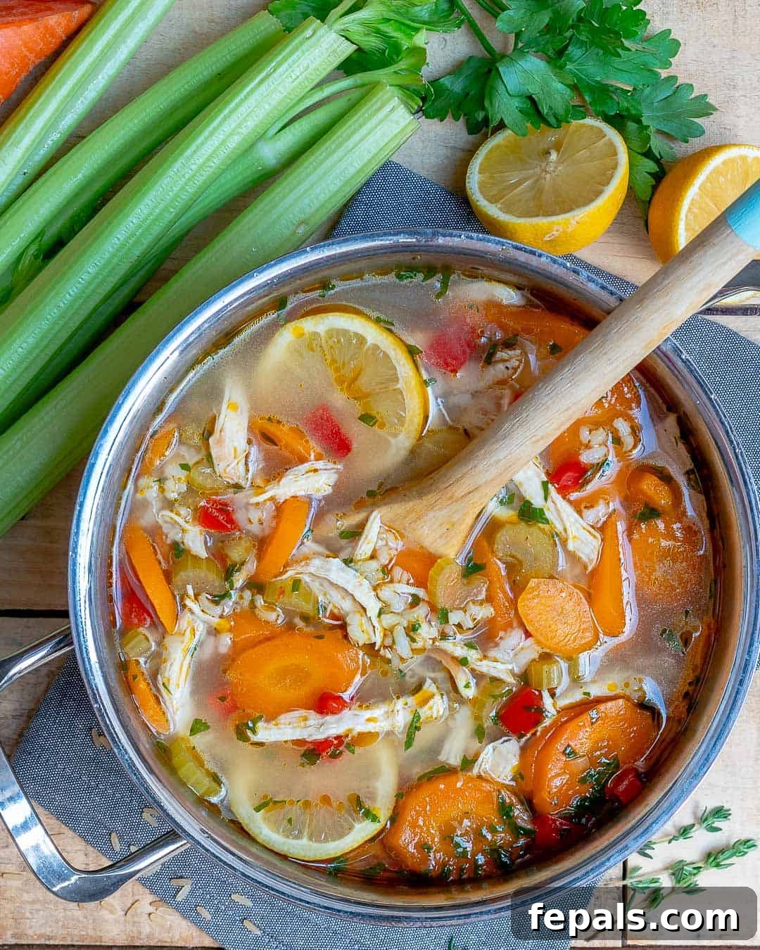 Close-up of a rustic bowl of lemon chicken and rice soup, steaming gently and garnished with fresh parsley.