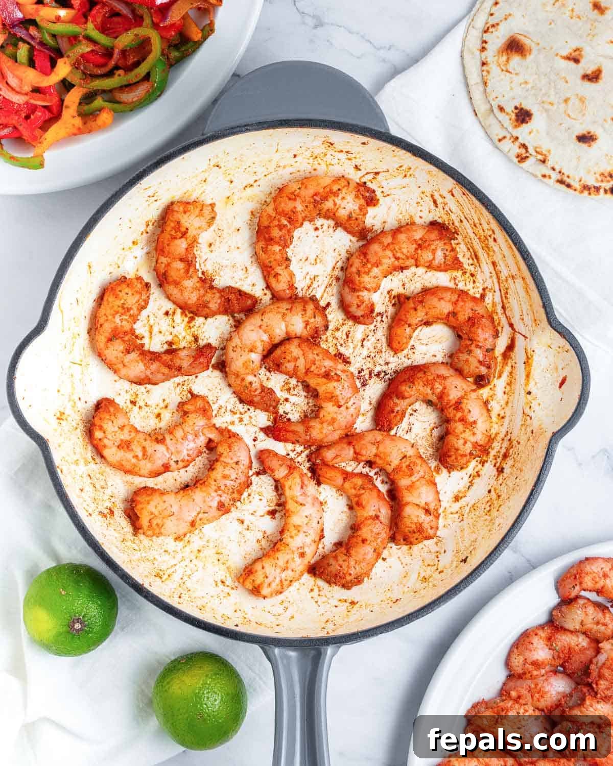 The seasoned shrimp being added to the hot skillet, ready to be quickly cooked until pink and curled.