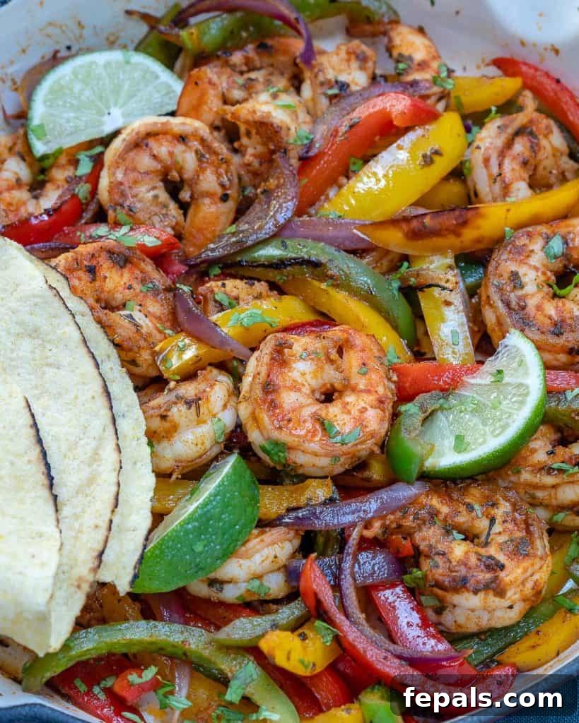 Close-up view of a vibrant skillet filled with tender shrimp fajitas, showcasing the perfectly cooked shrimp, bell peppers, and onions, ready for serving.
