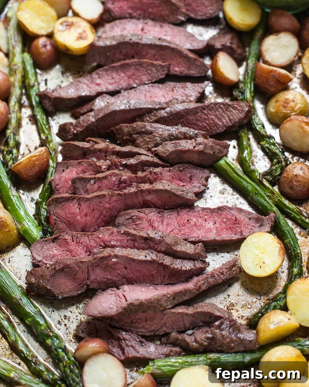 Sheet Pan Steakhouse Dinner 4 Sheet Pan Steak with Kale Pesto on baking sheet with cooked asparagus and baby potatoes, straight from the oven.