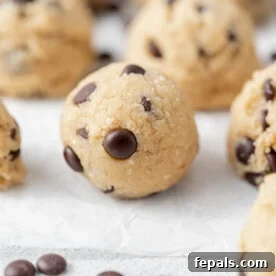 side shot of a ball of edible cookie dough bite on a parchment paper