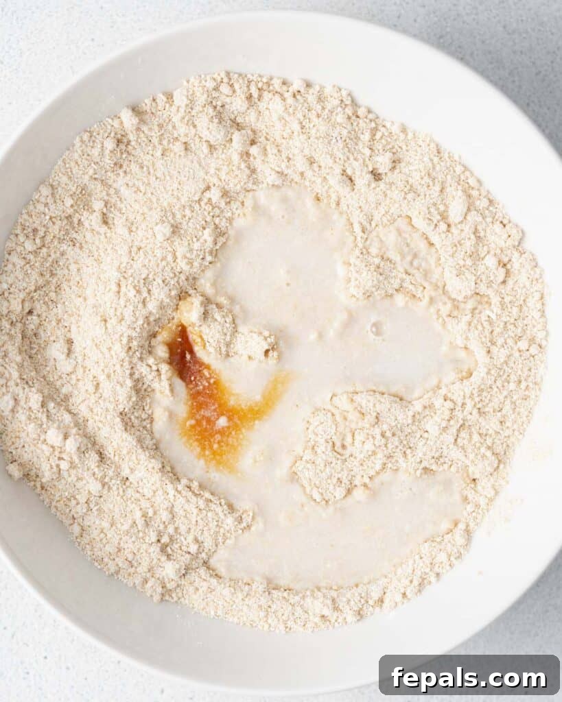 Wholesome Ready-to-Eat Cookie Dough 9 vanilla extract added over mixed flour in a bowl