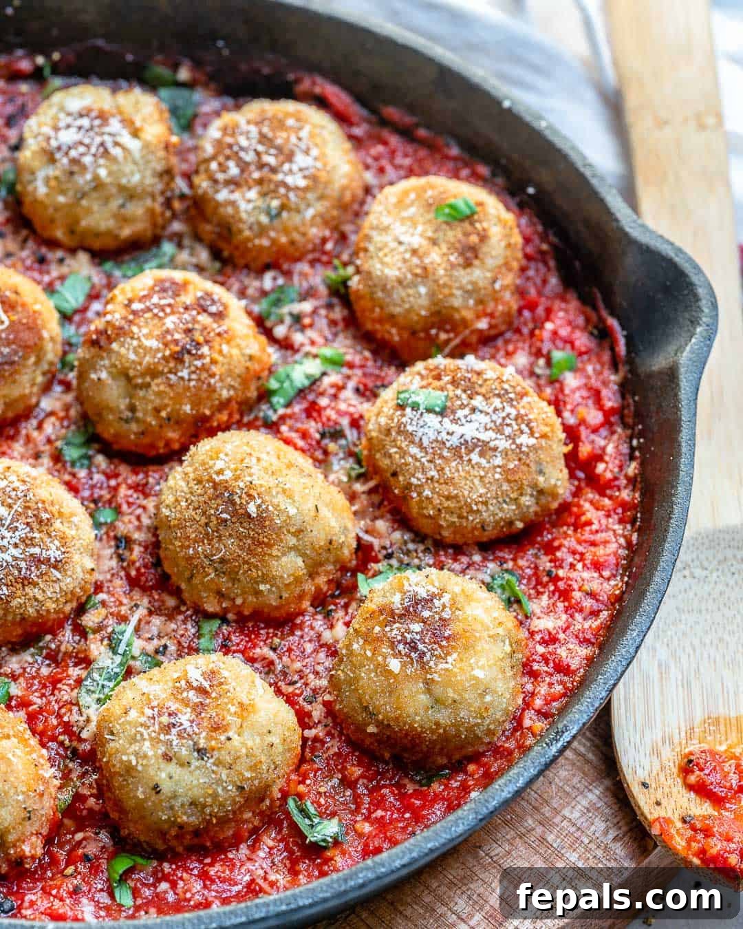 Easy Chicken Parmesan Meatballs with Tomato Sauce Large skillet showcasing perfectly cooked chicken parmesan meatballs immersed in a vibrant tomato sauce, ready for serving.