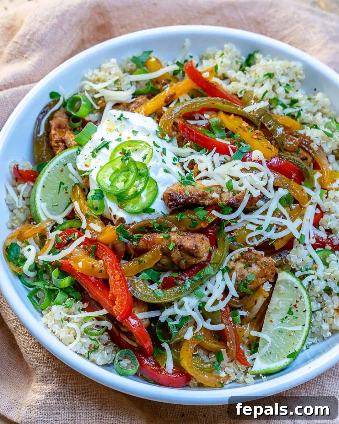 Flavorful baked chicken fajitas served over a bed of fluffy quinoa, garnished with fresh lime.