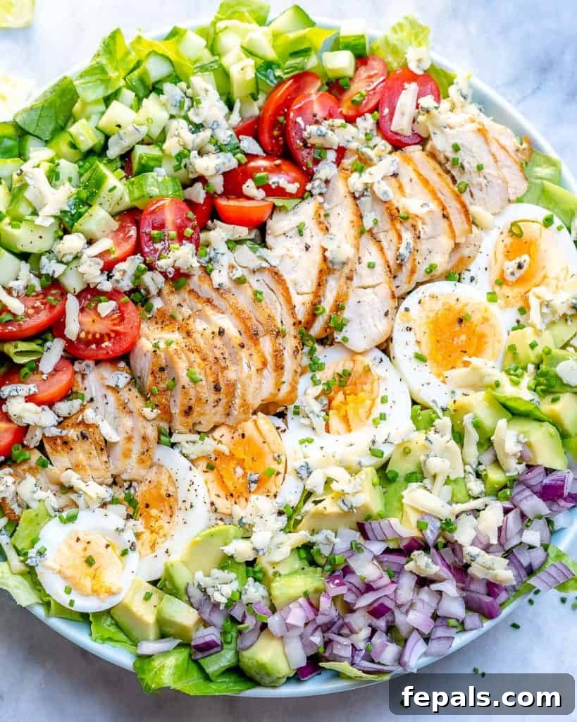 top close up view of chicken cobb salad with sliced boiled eggs and chopped veggies 