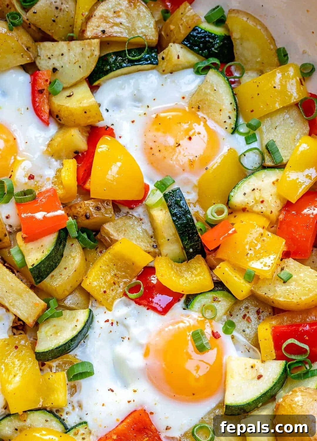 Sunrise Skillet with Eggs and Garden Harvest 3 Close-up view of perfectly cooked eggs nestled among sautéed vegetables in a skillet, showcasing the crisp-tender texture and vibrant colors.