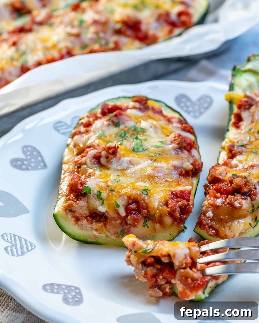 Zucchini lasagna boats layered with cheese and meat sauce, ready for baking