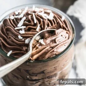spoon getting a bite of the chocolate mousse in a clear cup.