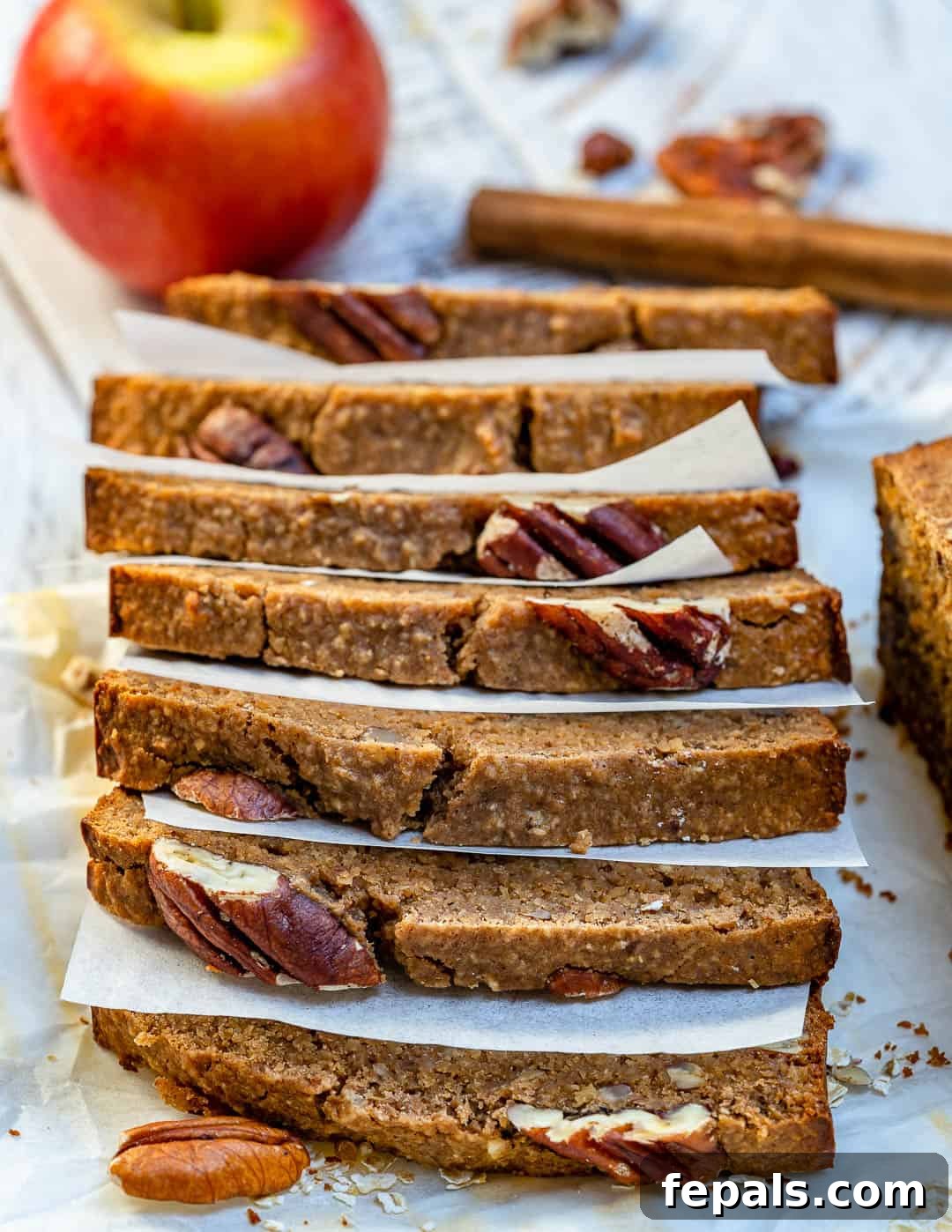 Stacked slices of apple cinnamon bread on parchment paper.