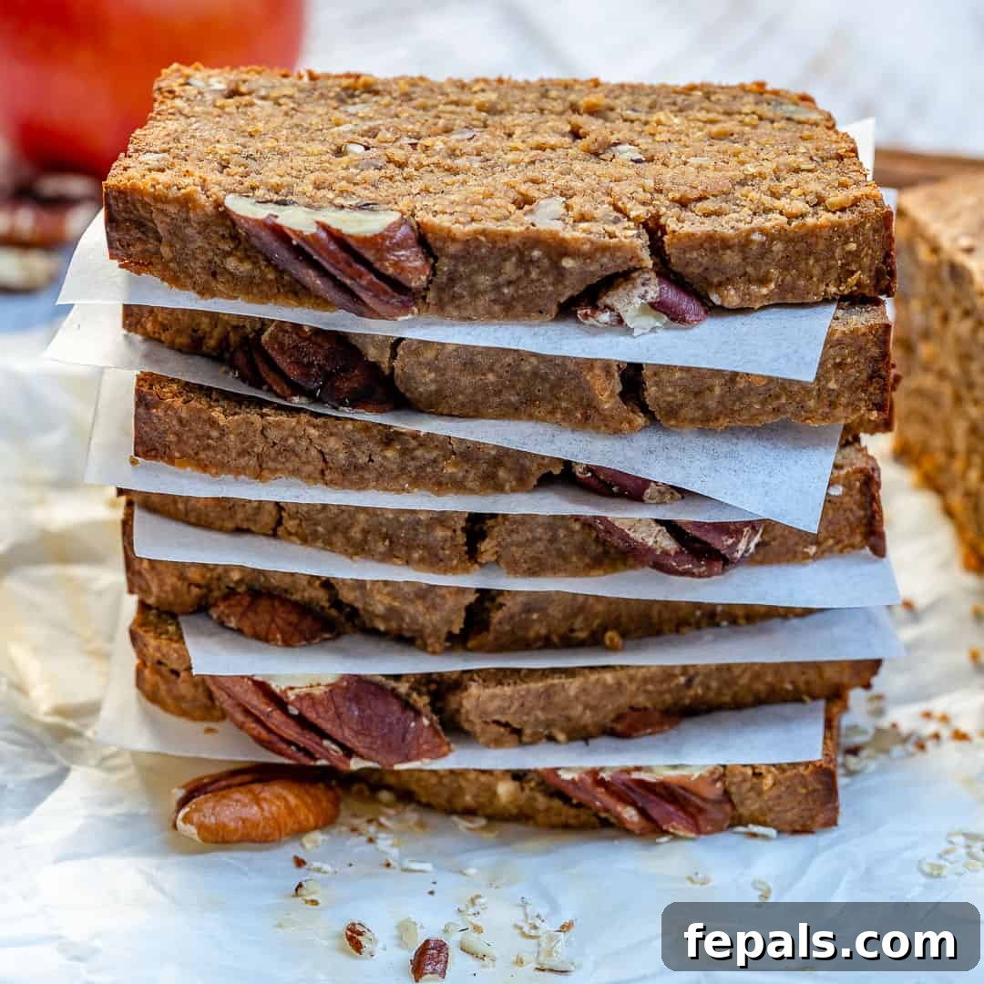 Several slices of cinnamon bread stacked with parchment paper between each slice, ready for serving.