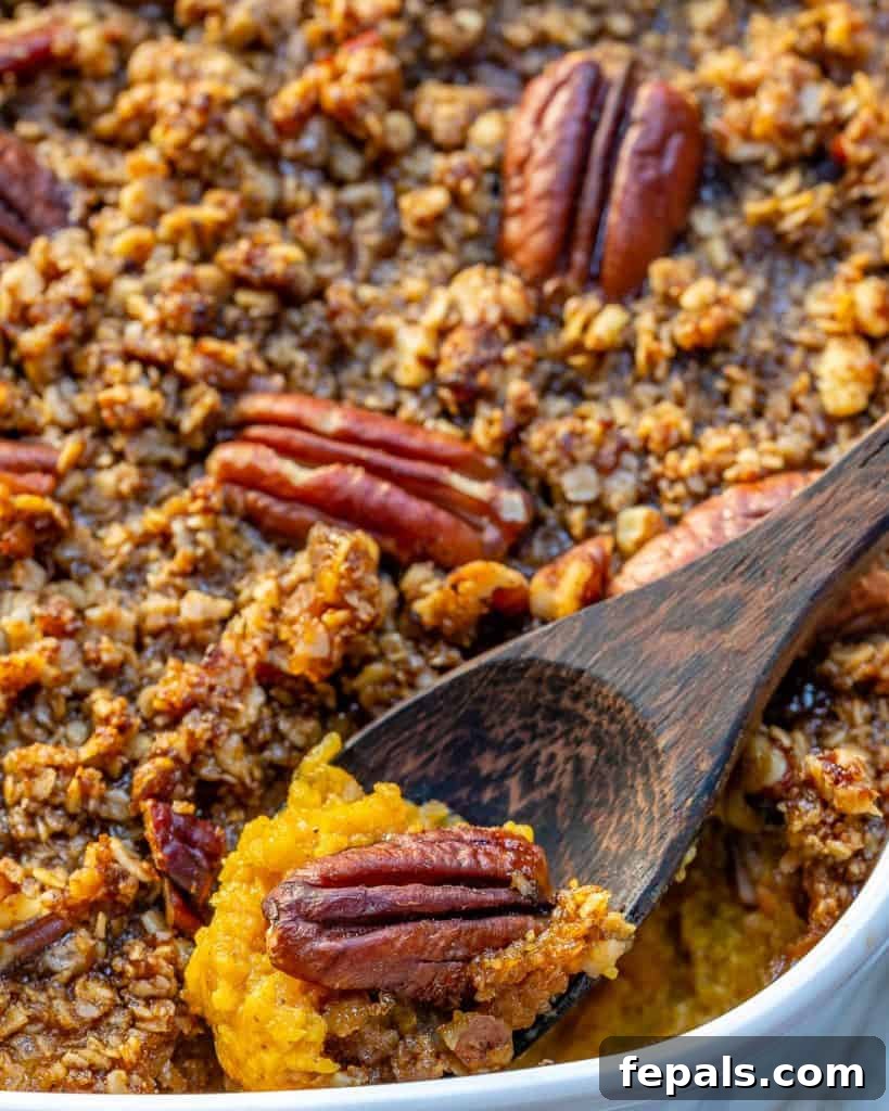 close up dish with squash casserole with wooden spoon taking a portion from dish