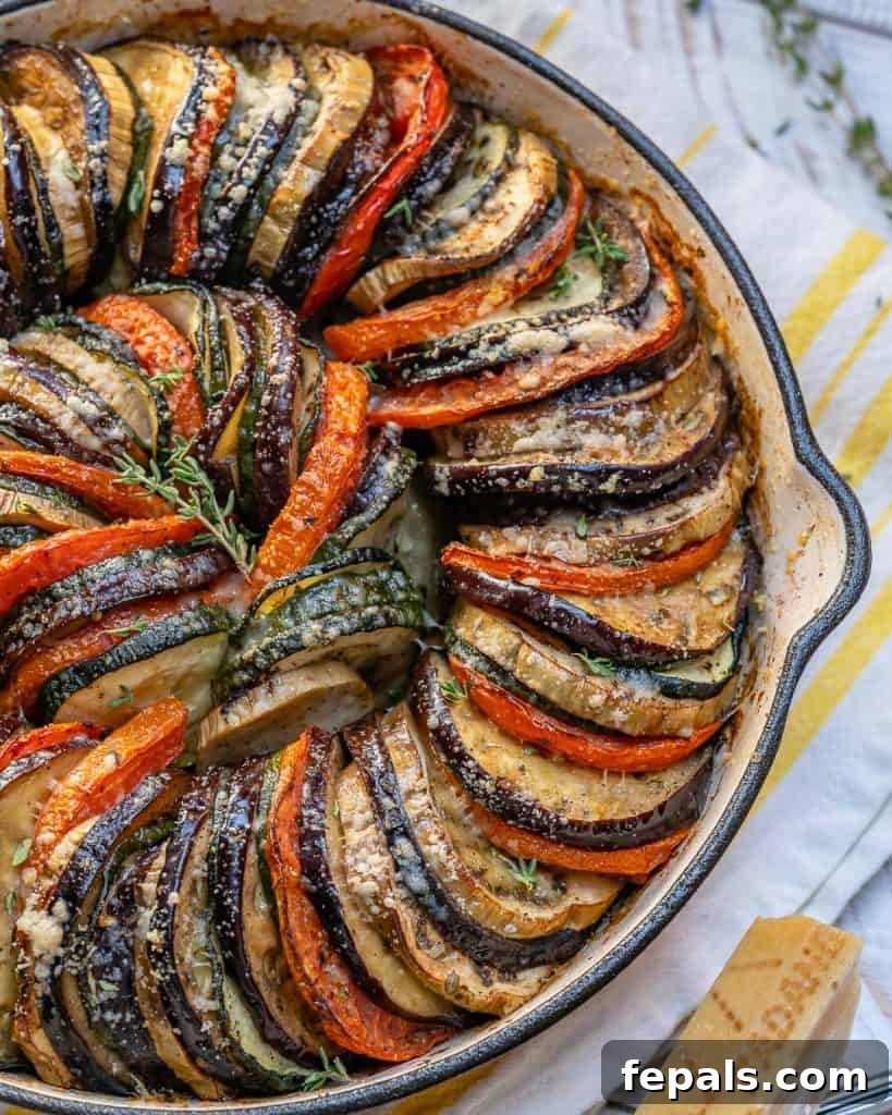 top view of half a skillet showing that has baked slices of eggplants, tomatoes, and zucchini