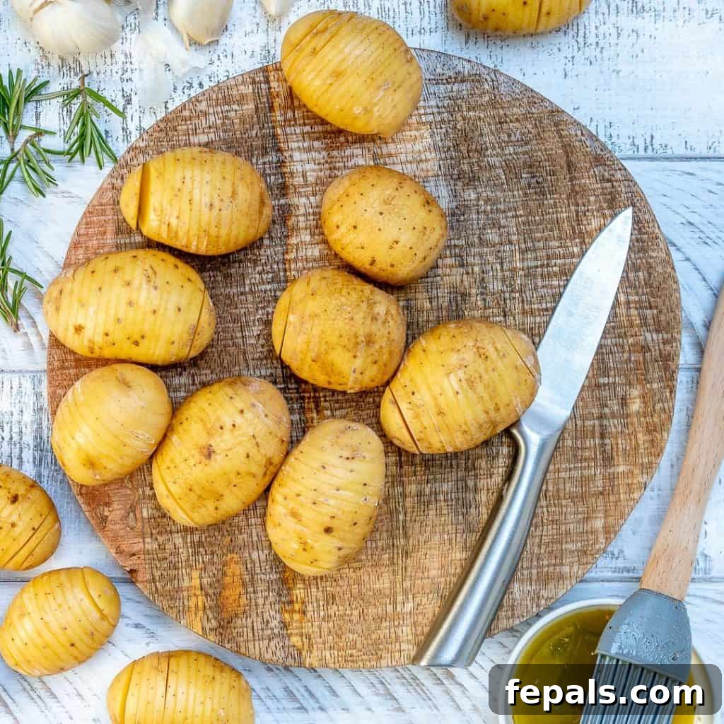 Golden Accordion Potatoes 4 gold potatoes on a round cutting board with a knife of the right of the potatoes