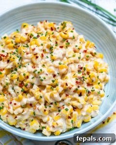 Velvety One-Pot Cheesy Corn 16 side shot of a plate with cheesy creamed corn side dish topped with chili flakes
