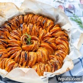 sliced sweet potatoes roasted in a dish on parchment paper.