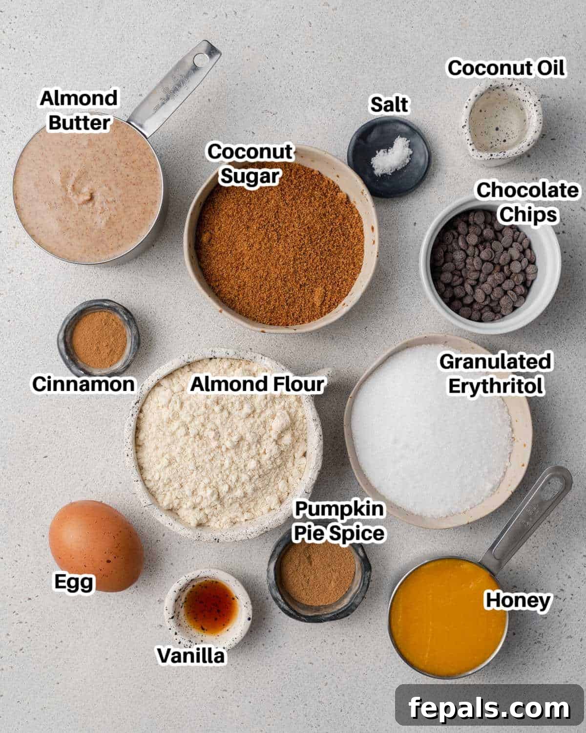 Various ingredients for pumpkin bars laid out in small ceramic bowls.