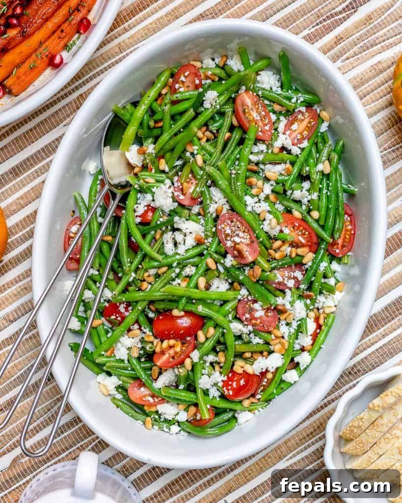 Sun-Kissed Tomato and Crisp Green Bean Salad 4 A vibrant bowl of green bean salad, showcasing the fresh ingredients including cherry tomatoes, pine nuts, and feta cheese, captured from a top-down perspective.