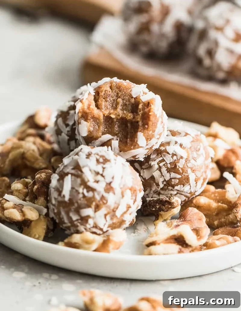 Side view of a bite-sized date energy ball on a plate, showing its rich texture.