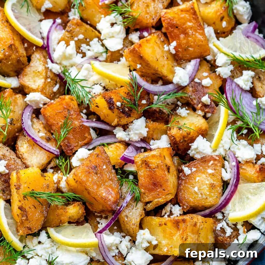 Zesty Greek Roasted Potatoes 3 overhead shot of Crispy Greek potato bake with garnishes like lemon slices, purple onions, and fresh dill