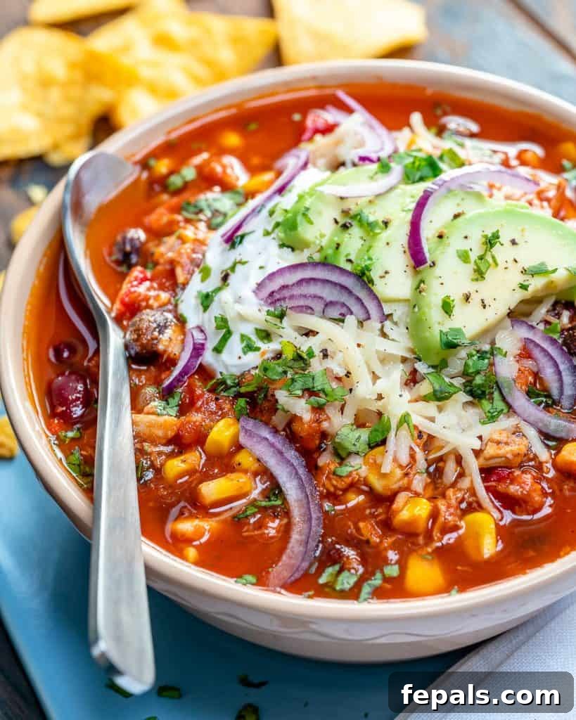 Ultimate Chicken Chili 9 side shot of chicken chili in a bowl with spoon on the left side in the bowl