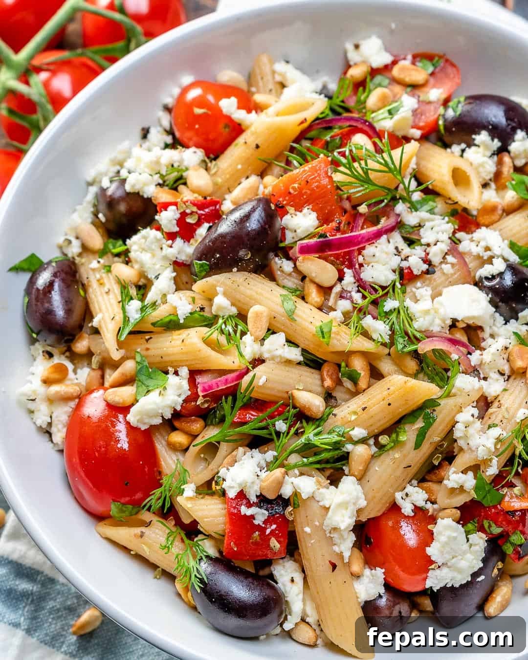 Fresh Greek Cherry Tomato Pasta 3 Overhead view of Easy Greek Cherry Tomato Pasta served in a white bowl, garnished with feta and herbs