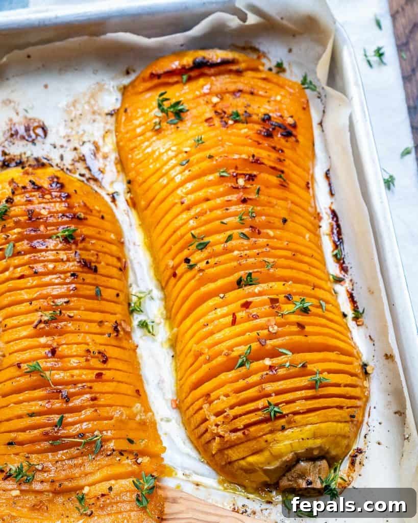 A close-up side view of roasted Hasselback butternut squash, showcasing the delicate slices.