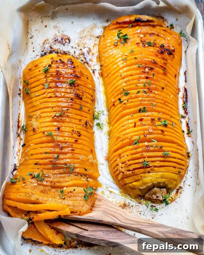 Top view of two roasted Hasselback butternut squash halves, showing rich color and texture.