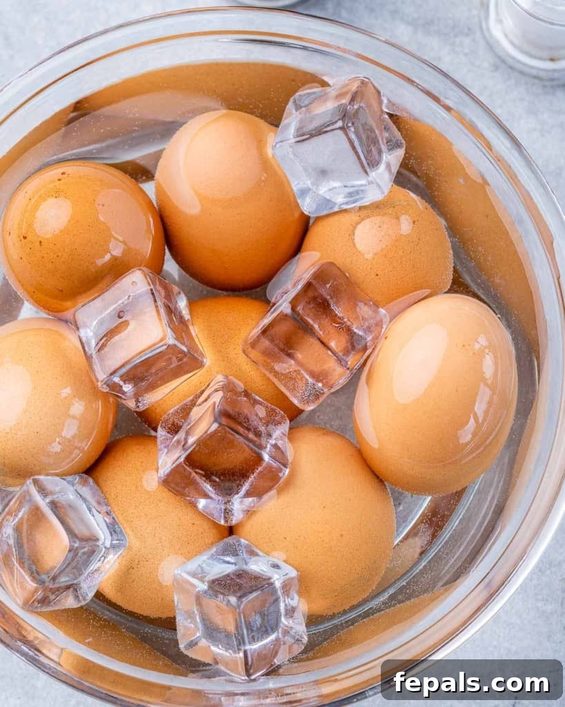 Guilt-Free Deviled Delights 4 Hard-boiled eggs cooling in an ice bath, a key step for easy peeling